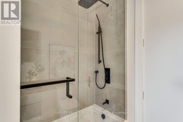 Modern bathroom with glass shower, rainfall showerhead, and black fixtures - 179 Palmerston Avenue Toronto