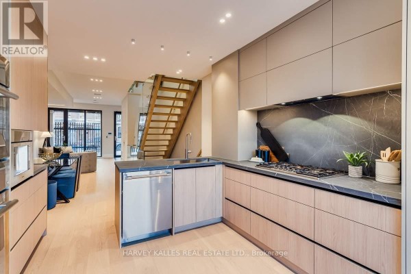 Modern kitchen with marble backsplash, wood cabinets, and gas stovetop - 179 Palmerston Avenue Toronto