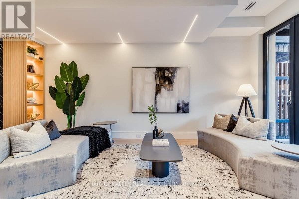 Curved sofas, abstract art, and modern lighting in living room - 179 Palmerston Avenue Toronto