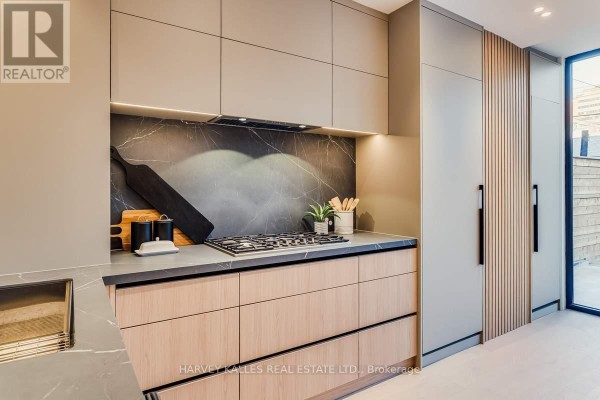 Modern kitchen with gas stovetop, marble backsplash, wood cabinets, and built-in appliances - 179 Palmerston Avenue Toronto