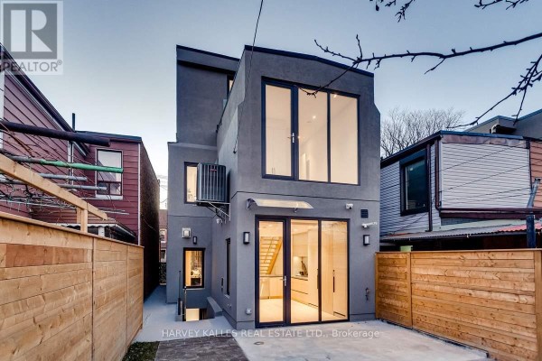Modern home with large windows & glass doors, wooden fence - 179 Palmerston Avenue Toronto