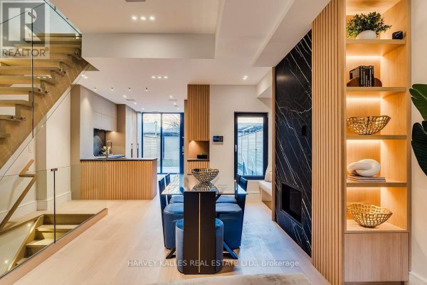 Modern living room with fireplace, shelving, and dining set - 179 Palmerston Avenue Toronto