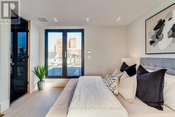 Bedroom with king bed, modern art, and city view - 179 Palmerston Avenue Toronto