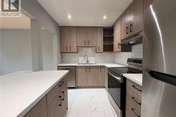 U-shaped kitchen with stainless steel appliances, light wood cabinets, white quartz countertops, and white subway tile backsplash. - 1797 Main Street W Unit# 4, Hamilton