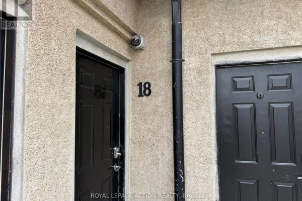 Close-up of apartment doors numbered 18 and 87, with exterior camera and downspout. - 18 - 12 Bridgeport Road E, Waterloo
