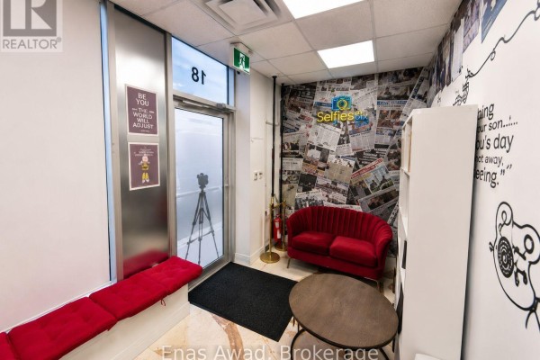 Interior waiting area with red benches, a small table, and patterned wallpaper. - 18 - 1235 Queensway Avenue E, Mississauga