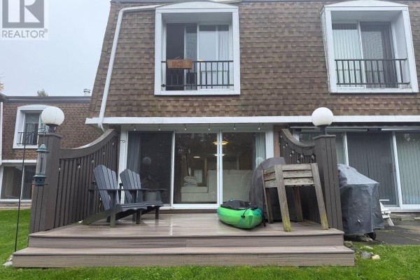 Backyard deck with two chairs, a kayak, and a barbecue covered by a tarp. - 18 - 2 Paradise Boulevard, Ramara