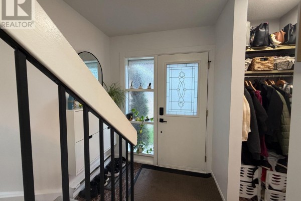 View of the townhouse entrance with a white door, shoe rack, and coat closet. - 18 - 2 Paradise Boulevard, Ramara