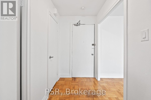 Bright living room with large windows, parquet flooring, and white walls - 18 - 69 Old Mill Terrace, Toronto