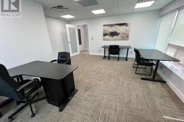Office with desks, chairs, patterned carpet, and a doorway to another room. - 18 2nd - 120 Woodstream Boulevard, Vaughan