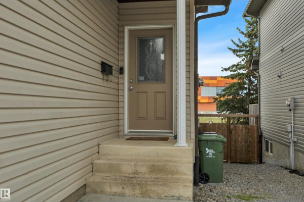 Kitchen with grey cabinets, a double sink, black appliances, and a textured backsplash. - #18 4900 62 St, Beaumont