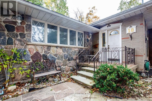 Close-up of the home's entrance with stone facade, steps, and decorative metal railings. - 18 Adamson Street S, Halton Hills
