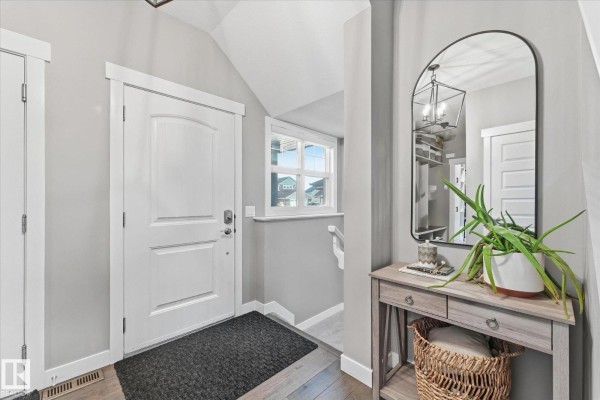 Entrance hallway with a white door, grey walls, and a wooden console table. - 18 Altadena, Sherwood Park
