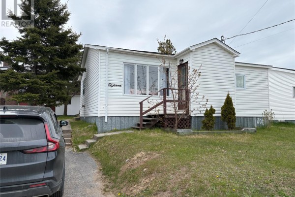 Front exterior of a white siding house with a wooden deck and stairs. - 18 Atlantic Avenue, Stephenville