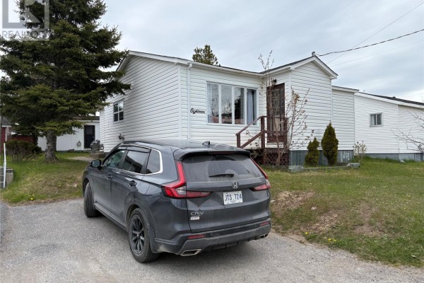 Front exterior of a white siding house with a parked dark grey SUV. - 18 Atlantic Avenue, Stephenville