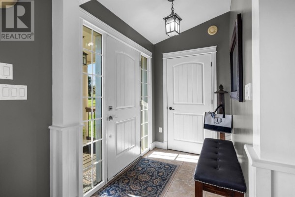 Interior entryway with dark gray walls, white trim, bench, and doors. - 18 Cedar Avenue, Charlottetown