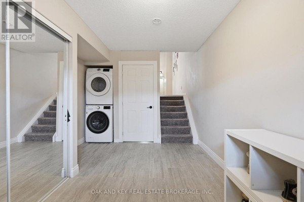 Stacked washer and dryer, mirrored closet, and carpeted stairs - 18 Chapman Court London North