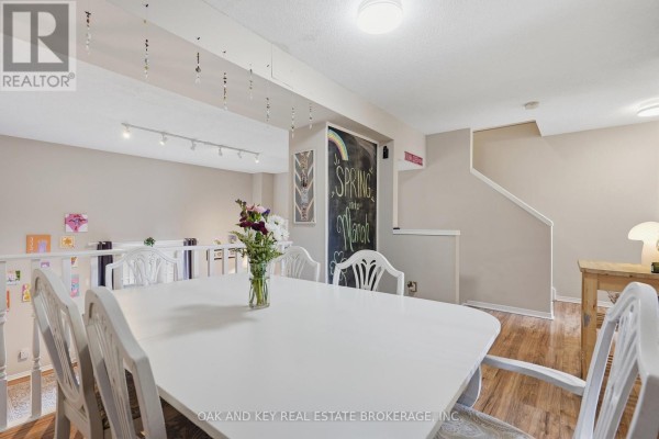 Dining room with white table and chairs, chalkboard, and staircase - 18 Chapman Court London North