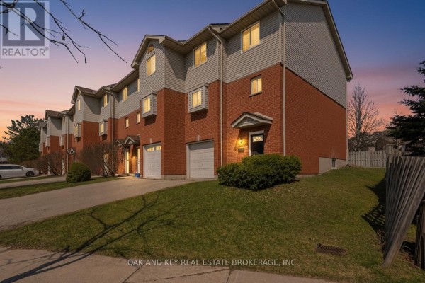 Townhouses with brick and vinyl siding, garages, and driveways - 18 Chapman Court London North