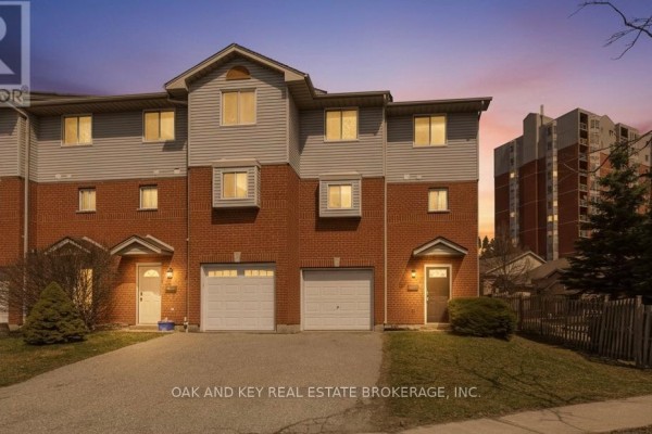 Townhouse exterior with brick, vinyl siding, garages, and front entrance - 18 Chapman Court London North