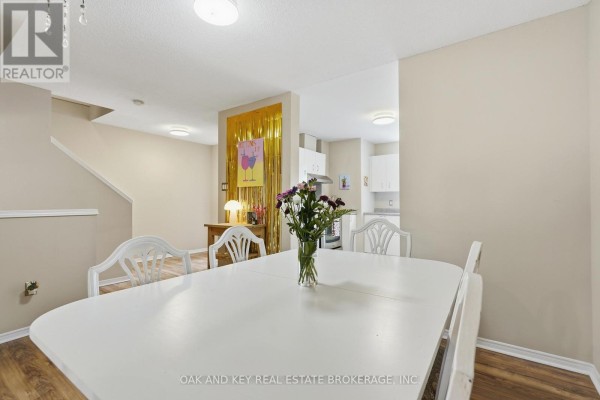White dining table and chairs, gold fringe backdrop, and open kitchen - 18 Chapman Court London North