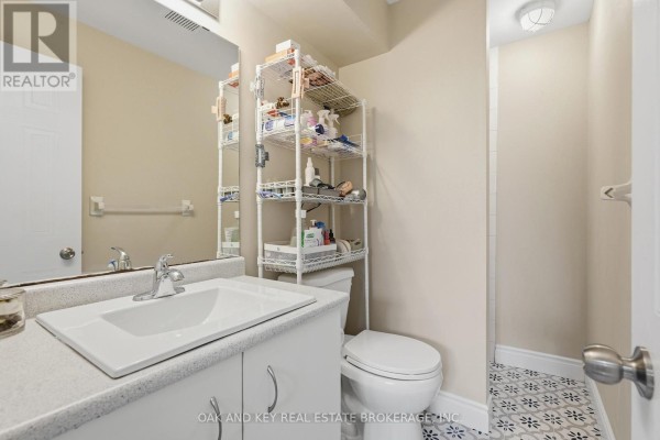 Bathroom vanity, toilet, and decorative floor tiles - 18 Chapman Court London North