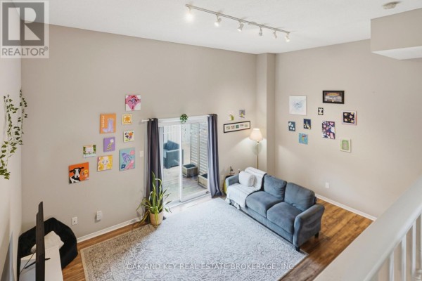 Living room with vaulted ceiling, blue sofa, sliding door, and artwork - 18 Chapman Court London North