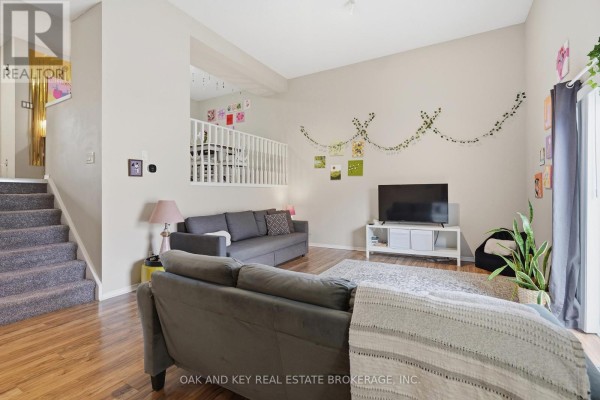 Living room with vaulted ceiling, sectional sofa, TV and stairs - 18 Chapman Court London North