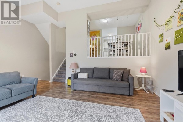 Living room with gray sofa, rug, and stairs to dining area - 18 Chapman Court London North