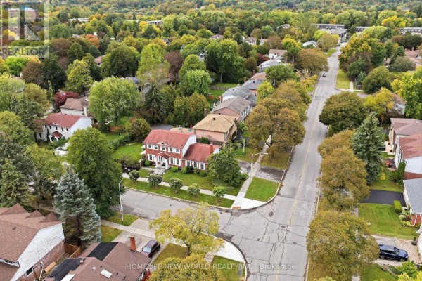 Aerial view of houses on a street with mature trees in a suburban neighborhood. - 18 Dolan Gate, Toronto