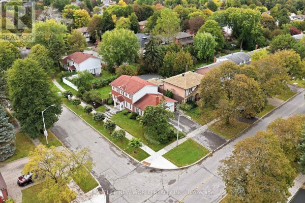 Aerial view of a residential street with brick homes and green lawns. - 18 Dolan Gate, Toronto