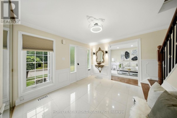 Tiled foyer with a console table, mirror, and doorway to a living room. - 18 Dolan Gate, Toronto