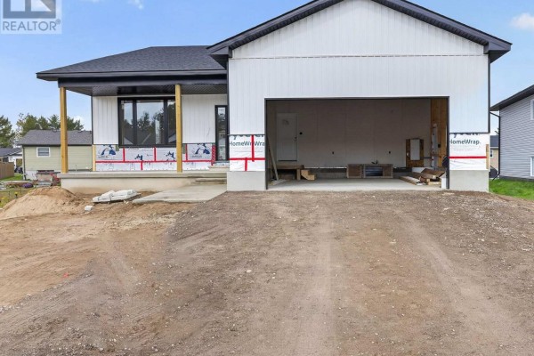 A two-story townhouse complex with light green siding and dark green trim on a sunny day. - 18 Durant Street, Petawawa