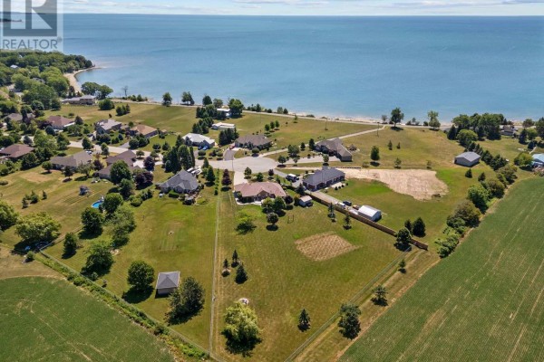 Aerial view of a residential neighborhood with houses and fields near a large blue body of water. - 18 Featherstone Avenue, Haldimand