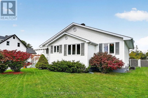 Side view of the white bungalow showing windows and shrubs in the front yard. - 18 Frost Avenue, South Stormont