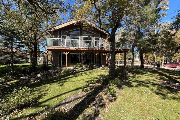 Front exterior of a two-story house with large windows on the upper level and a covered deck. - 18 Hawthorne Drive, Killarney
