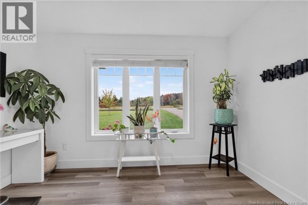 Interior room with grey wood-look flooring, white walls, and a large window overlooking a yard. - 18 Hope Road, Steeves Mountain