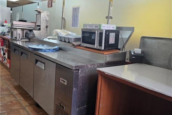 Commercial kitchen counter with stainless steel appliances and a microwave. - 18 Market Street Unit# B, Brantford