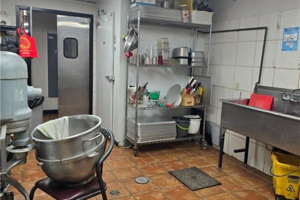 Commercial kitchen with a large mixer, shelving, and a stainless steel sink. - 18 Market Street Unit# B, Brantford