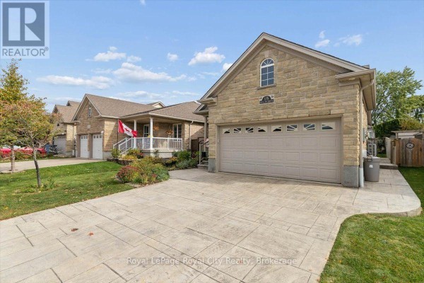 Side view of the house, highlighting the stone exterior, garage, and neighboring properties. - 18 Mullin Drive, Guelph