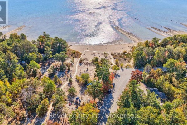 Aerial view of a sandy beach and calm water, surrounded by trees with autumn foliage. - 18 Rue Vanier Road, Tiny