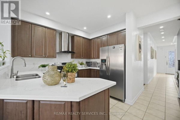 Interior entryway with a white door, mirrored closet, tiled floor, and a potted plant. - 18 Seedland Crescent, Brampton