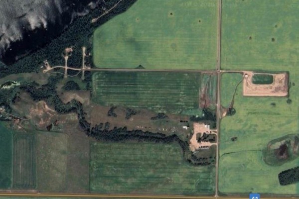 Satellite view showing agricultural fields, wooded areas, a lake, and roads surrounding the property. - 18 Wakonda Drive, Hoodoo Rm No  401