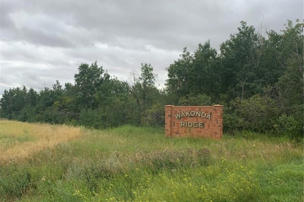 Stone monument sign for Wakonda Ridge in a grassy field with trees and vegetation in the background. - 18 Wakonda Drive, Hoodoo Rm No  401
