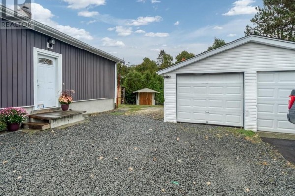 View of the detached double garage and a small shed in the backyard. - 18 Wickwas Street, Onaping