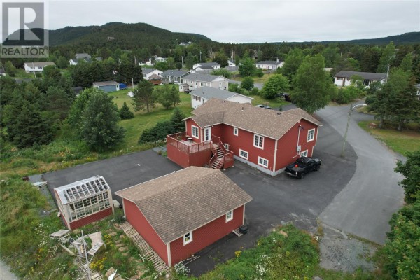 Aerial view of the rear of the red house, deck, and detached garage with surrounding neighborhood. - 18 Wilsonville Avenue, Clarke’s Beach