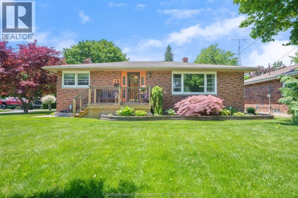 View of the paved walkway leading to the wooden porch steps of a brick house. - 18 Woodland Avenue, Chatham