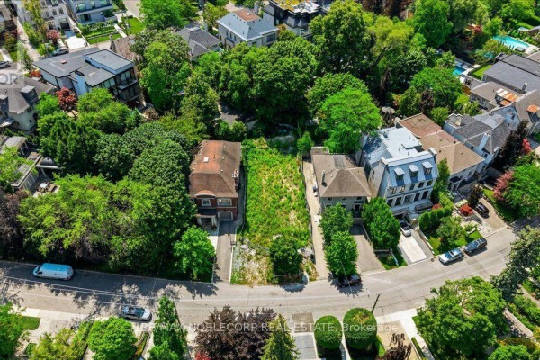 Aerial view showcasing the vacant lot at 180 Dunvegan Road, Toronto, nestled among lush green trees and established residences. - 180 Dunvegan Road, Toronto