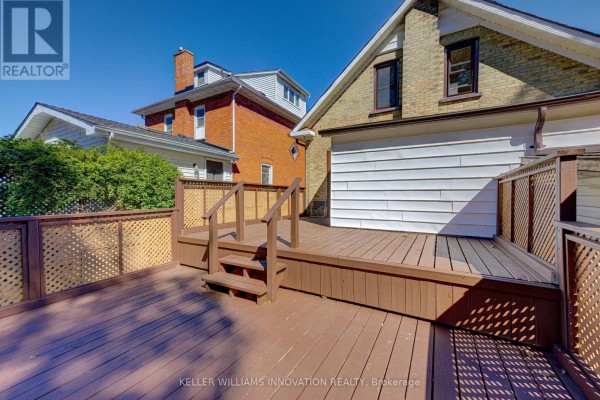 Bedroom with light wood laminate flooring, a ceiling fan, and a window overlooking the backyard. - 180 Hewat Street, Cambridge