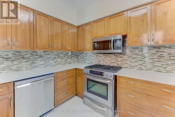 Kitchen with light wood cabinets, stainless steel appliances, and a mosaic tile backsplash. - 180 Hewat Street, Cambridge